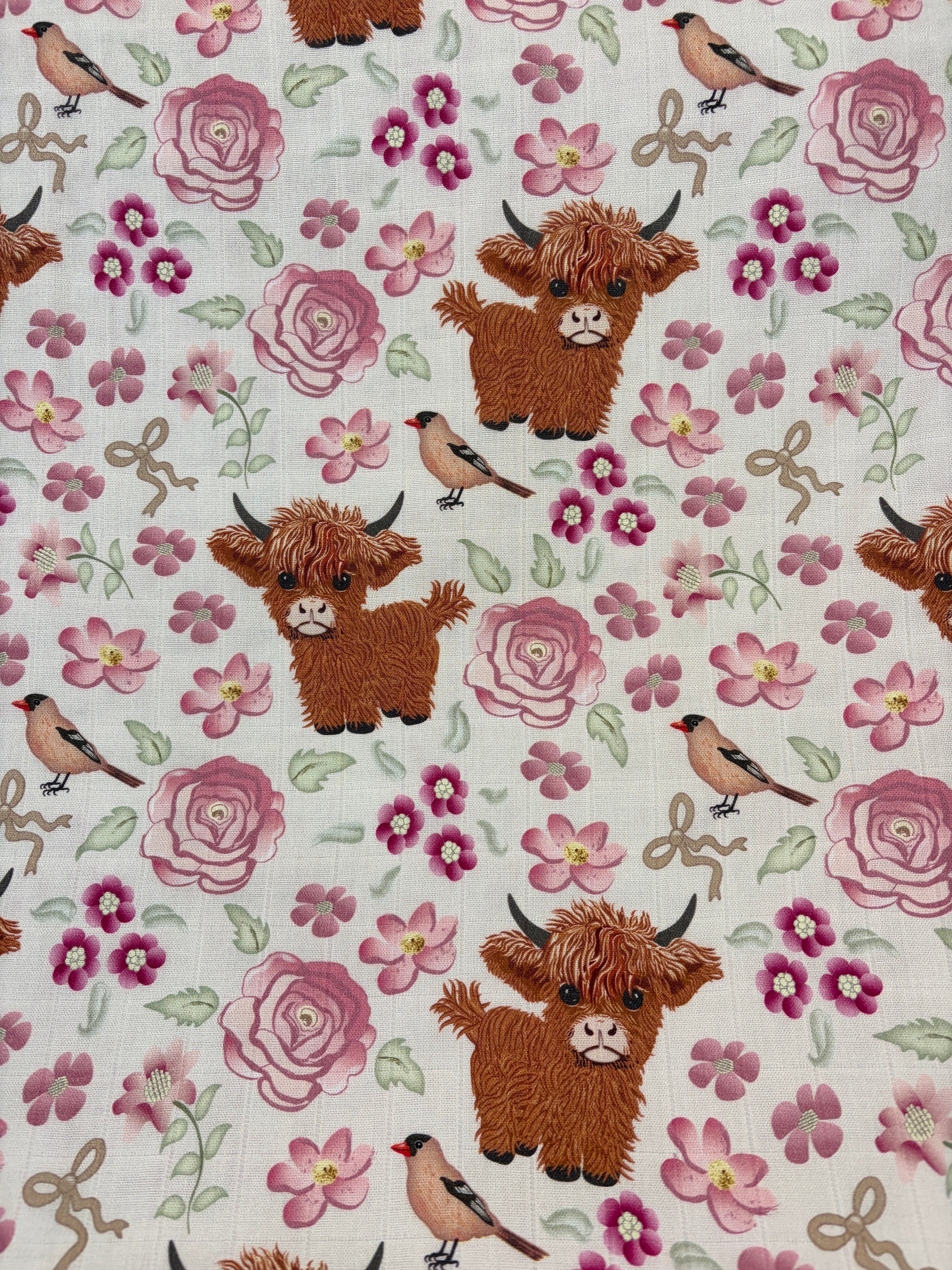 Vaches Highland dans un jardin fleuri rose